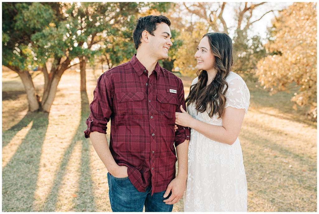 Engaged couple posing for portraits in the fall at the Lubbock Memorial Arboretum
