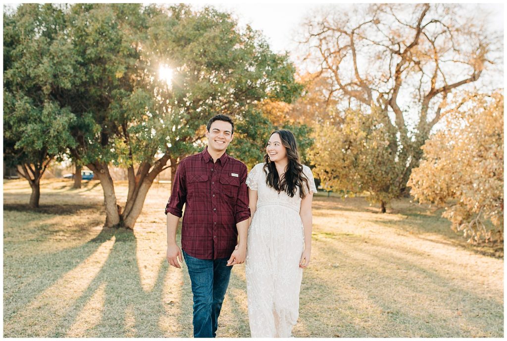 Engaged couple posing for portraits in the fall at the Lubbock Memorial Arboretum