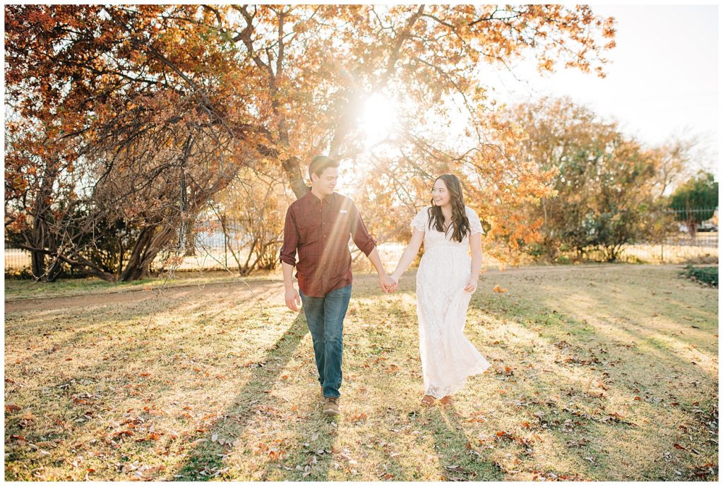 Engaged couple posing for portraits in the fall at the Lubbock Memorial Arboretum