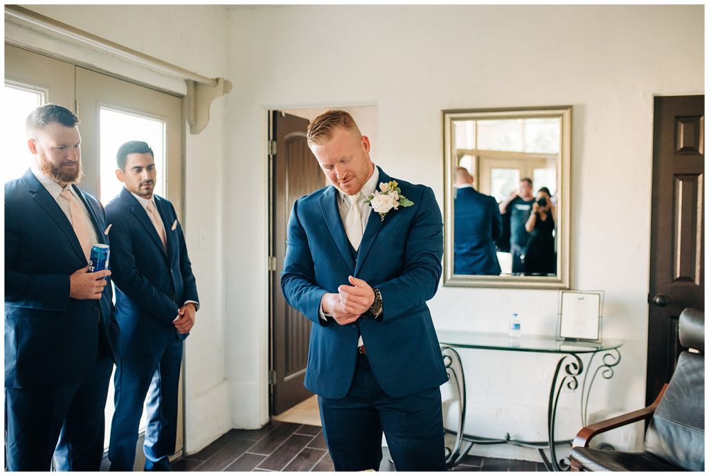groom in navy suit getting ready on wedding day