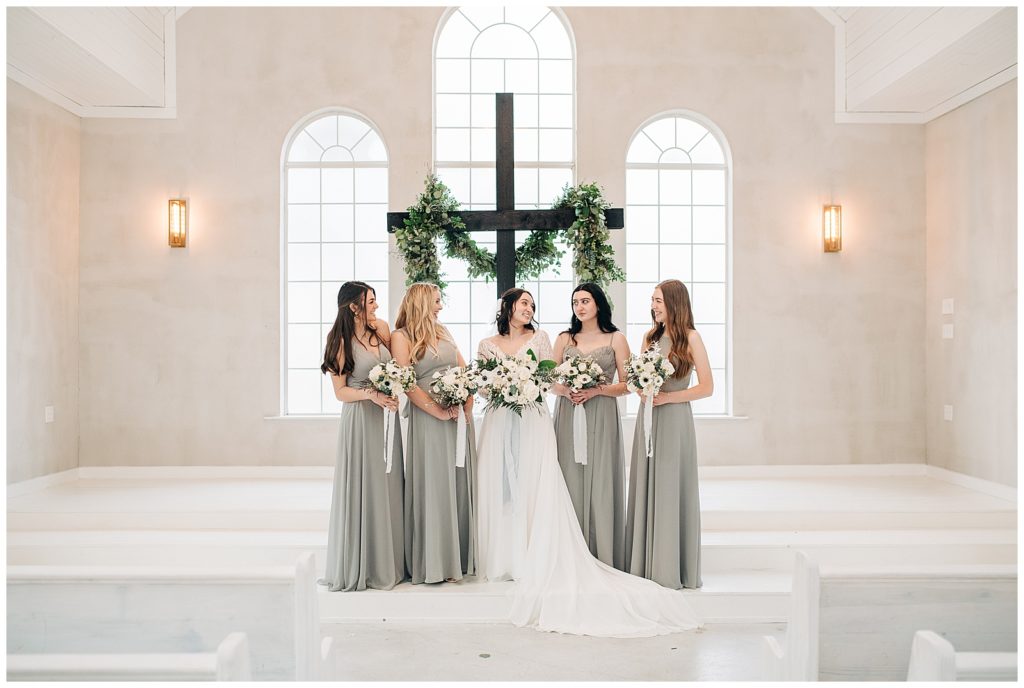 bridal party posing for portraits at wedding ceremony altar